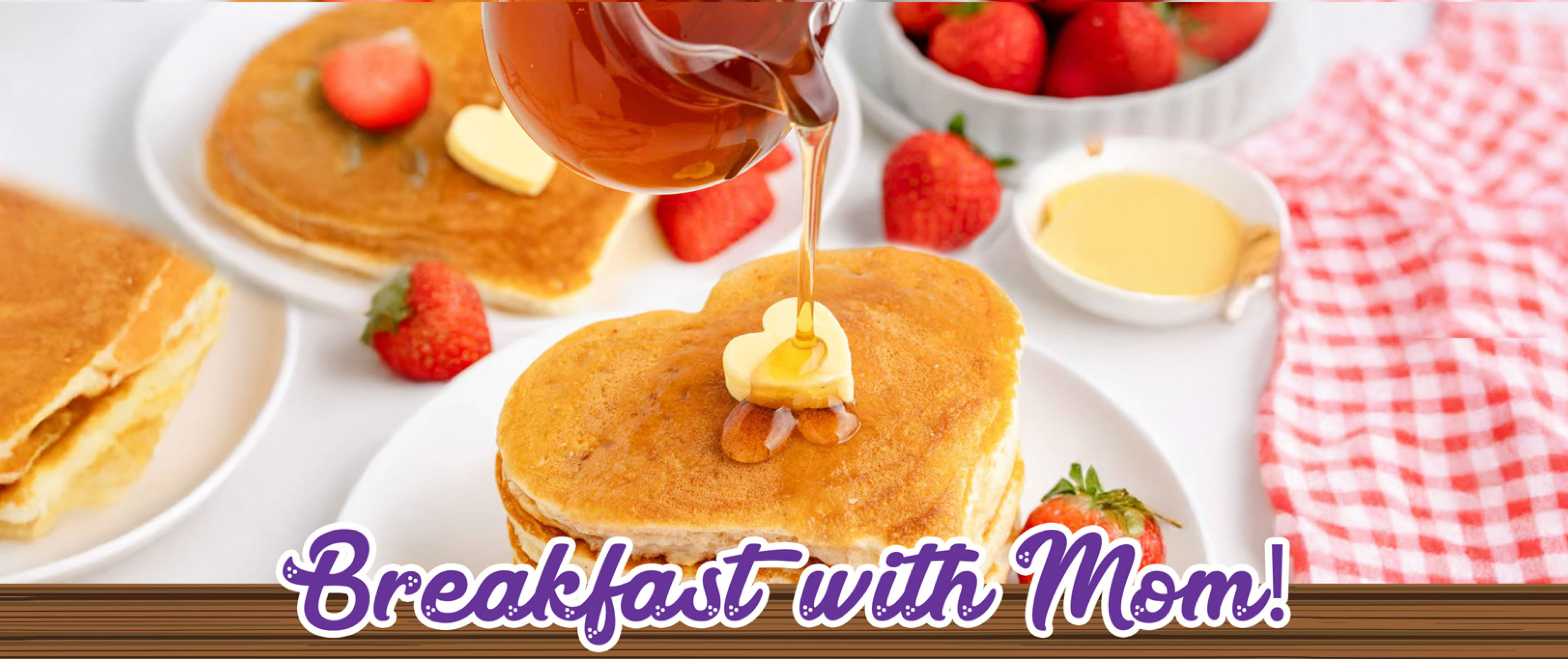 Heart-shaped pancakes with butter and syrup, surrounded by strawberries, a bowl of strawberries, and a red checkered napkin, with the text "Breakfast with Mom!" at the bottom.
